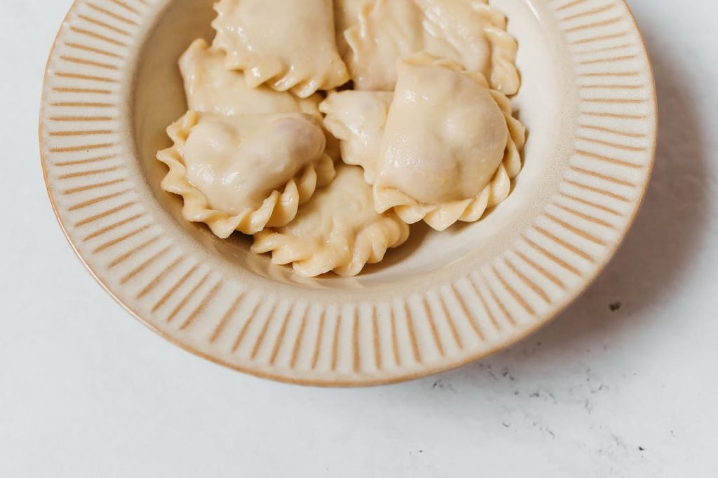 Delicious homemade vareniki dumplings served on a rustic ceramic plate. Perfect for food photography.